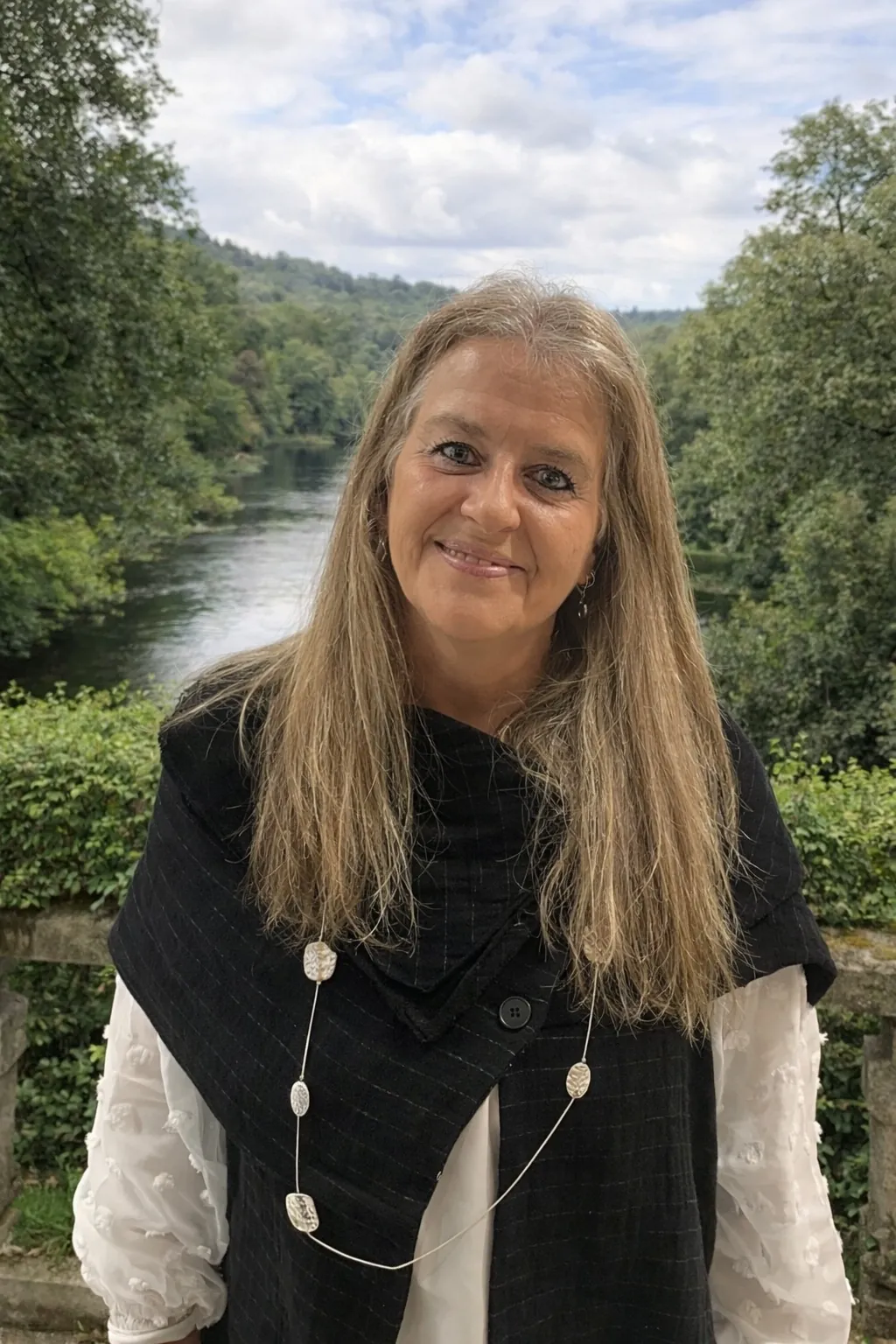 Sofia Cid sorridente junto a um rio, rodeada de árvores